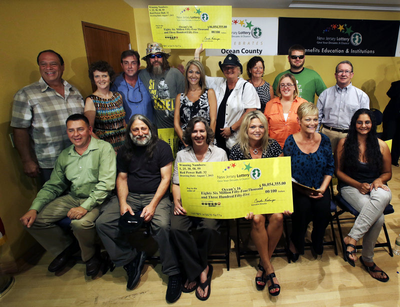 Lottery winners pose Tuesday in Toms River, N.J. The Ocean’s 16, as the group of Ocean County public workers calls itself, won a third of the $448 million Powerball jackpot.