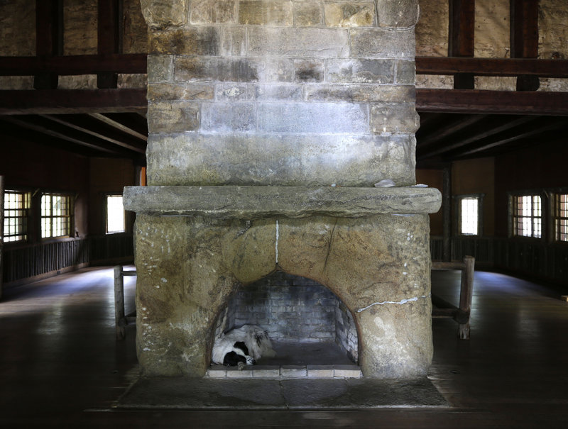 Swix, a dog owned by master carpenter Michael Frenette, naps in a fireplace in the main hall.