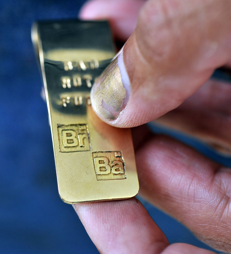Coco Corral of Biddeford, who created a money clip for "Breaking Bad" star Bryan Cranston five years ago, holds a recreation of the money clip for sale to others. Note the atomic symbols for bromine and barium, graphics the show uses for the "Breaking Bad" title sequence, symbolizing his character was a chemistry teacher before becoming a drug dealer.