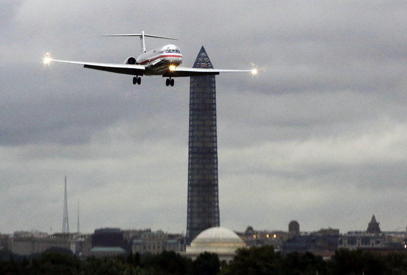 An American Airlines jet passes the Washington Monument as it lands at Ronald Reagan National Airport, in Washington, D.C. American and US Airways say that a merger between them would eliminate the service gaps and weaknesses they have as individual airlines.