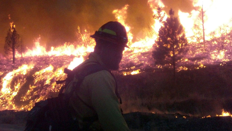 In a photo released Wednesday, a firefighter stands watch Monday near the edge of the Elk Complex fire outside Pine, Idaho. The lightning-caused fire has burned about 175 square miles.