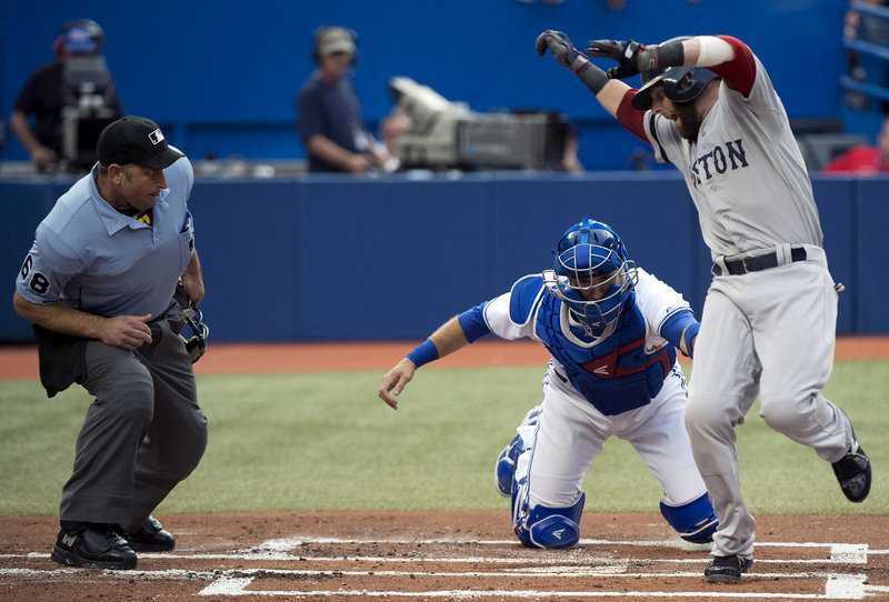 Dustin Pedroia of the Boston Red Sox tries to get around Toronto catcher J.P. Arencibia. Didn’t work, Pedroia was out and the Red Sox lost 2-1 to the Blue Jays in Toronto.