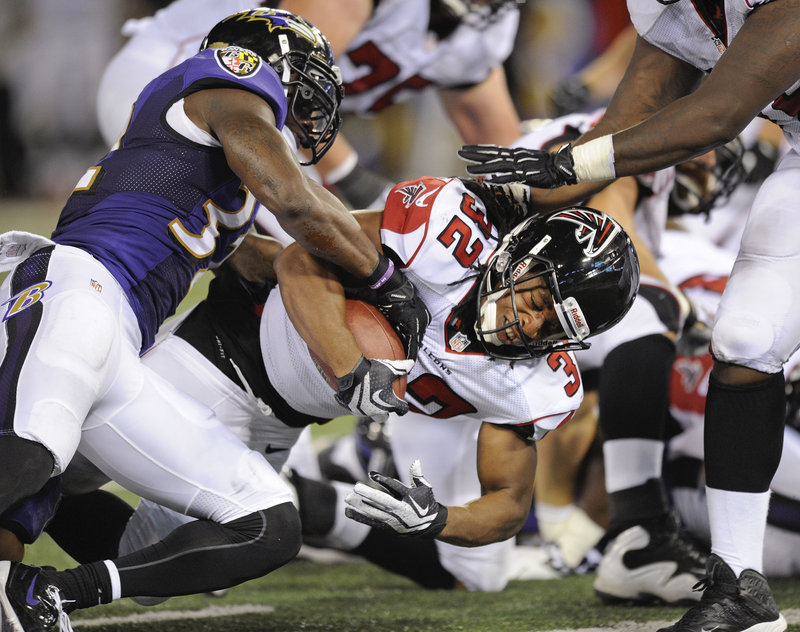 Jacquizz Rodgers of the Atlanta Falcons rolls into the end zone Thursday night as James Ihedigbo of Baltimore goes for the ball during the Ravens’ 27-23 victory in an exhibition game.