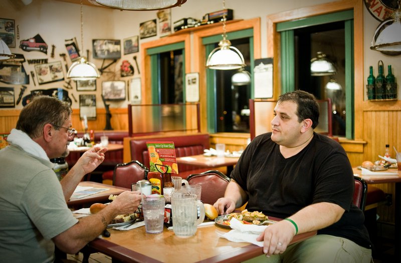 David Ryser, left, and son Charles Ryser of Forsyth, Ga., eat after showering at a truck stop recently in Bordentown, N.J. The Rysers oppose the federal rules to counter fatigue.