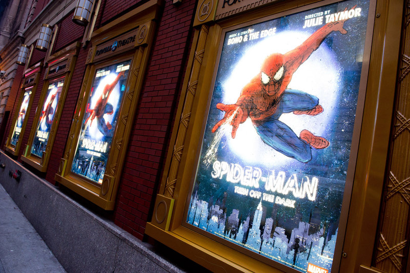 Posters for the Broadway musical "Spider-Man: Turn Off the Dark" hang outside the Foxwoods Theatre in New York.