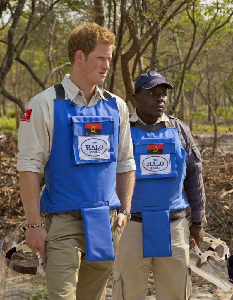 Prince Harry, left, tours a mine clearance site in Angola recently with HALO Trust provincial manager Tony Jose Antonio.