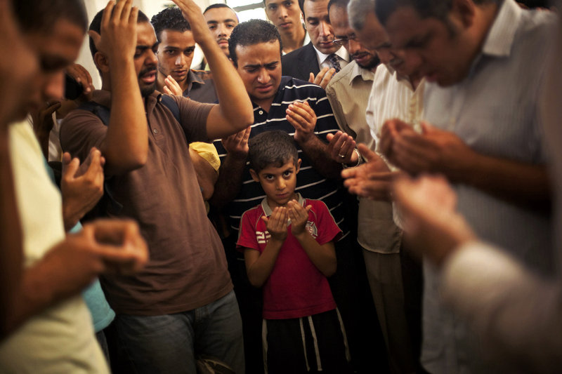 A young son of Ammar Badie prays during his father’s funeral in Cairo on Sunday. The son of the Muslim Brotherhood’s spiritual leader Mohammed Badie, Ammar Badie was killed by Egyptian security forces Friday in Cairo.