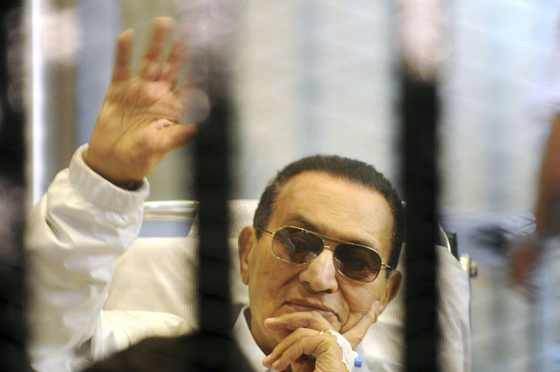 Former Egyptian President Hosni Mubarak waves to his supporters from behind bars April 13 as he attends a hearing in Cairo. Tensions in Egypt have intensified since the ouster of his successor, Mohammed Morsi.