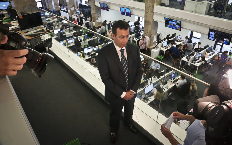 The Associated Press Ehab Al Shihabi, interim chief executive officer for Al-Jazeera America, listens during an interview overlooking the newsroom, after the network’s first broadcast Tuesday in New York. It aims to air just six minutes of commercials each hour.