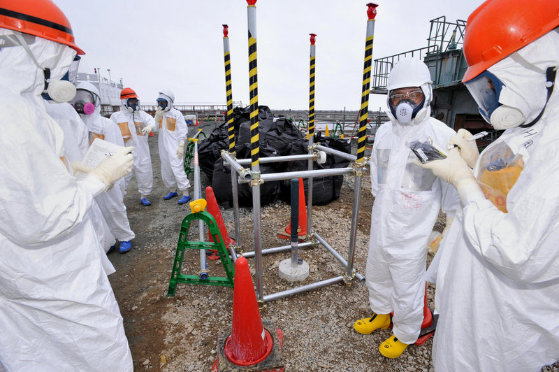 Reporters inspect an observation well, which was dug to take underground water samples near the Fukushima Dai-ichi nuclear plant in Okuma, northeastern Japan.