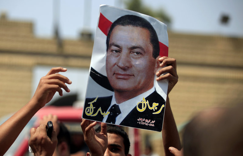 A supporter of Egypt’s deposed President Hosni Mubarak holds a poster of him in Cairo on Thursday.
