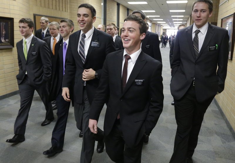 Mormon missionaries walk through the halls at the Missionary Training Center in Provo, Utah, in January. The church has lowered the minimum age for missionaries.