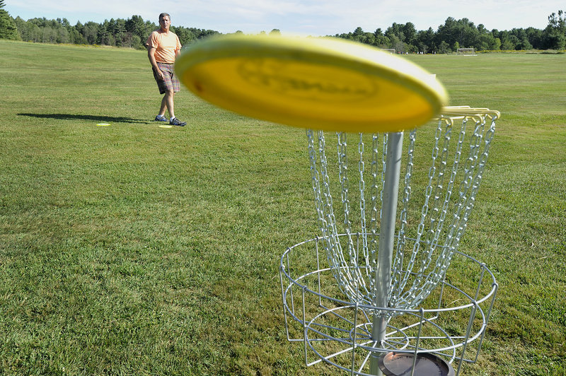 Peter Robinson watches his bid for a birdie sail just past the ninth hole Friday at the disc golf course the town of Cumberland created at its Twin Brook Park. Installing the course cost the town about $2,500, said Peter Bingham, the town’s recreation superintendent.