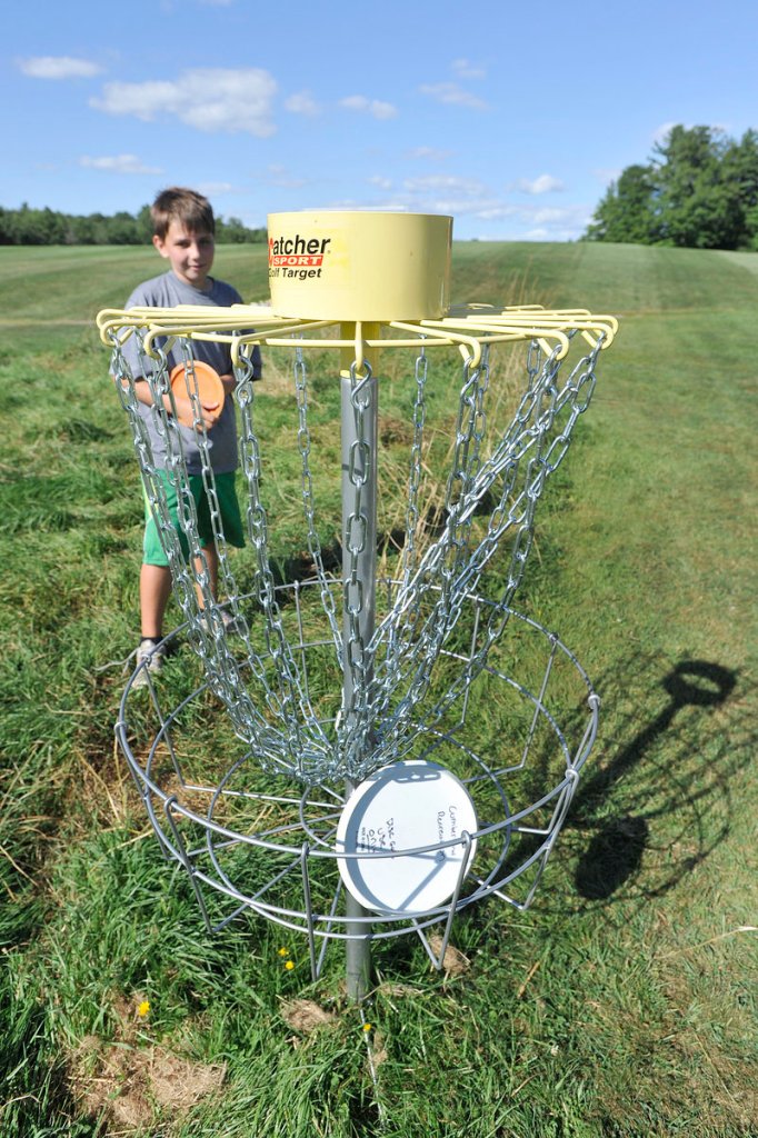 Zachary Whiting, 10, of Cumberland, waits for his turn to throw after a fellow player tossed his disc into the ninth hole Friday.