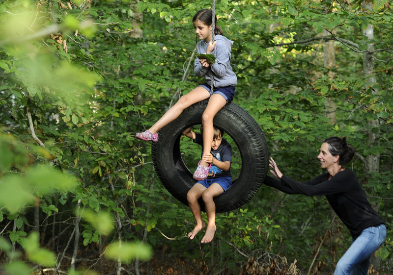 Scientist Natalie Boelman pushes her children, Aline Waldhauser, 6, and Nico Waldhauser, 4, on a tire swing behind their cottage at Woods Hole in Falmouth, Mass., on Aug. 15. “It’s like summer camp for all of us,” she said.