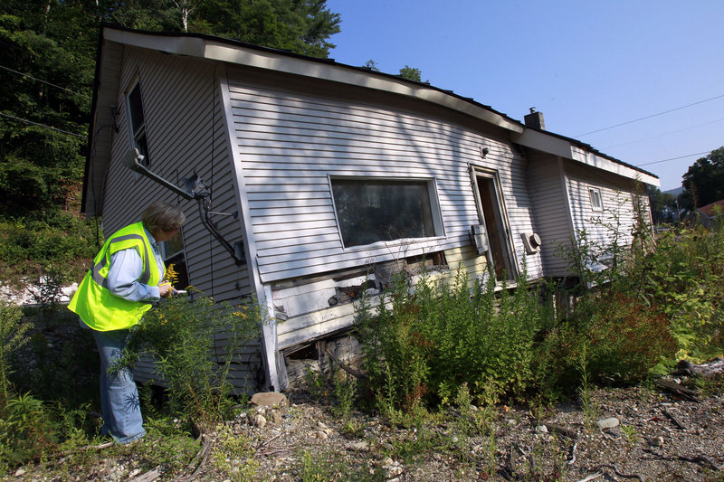 Cheryl Harvey of Harvey’s Plumbing and Excavating takes notes on a house to be demolished in Pittsfield, Vt.