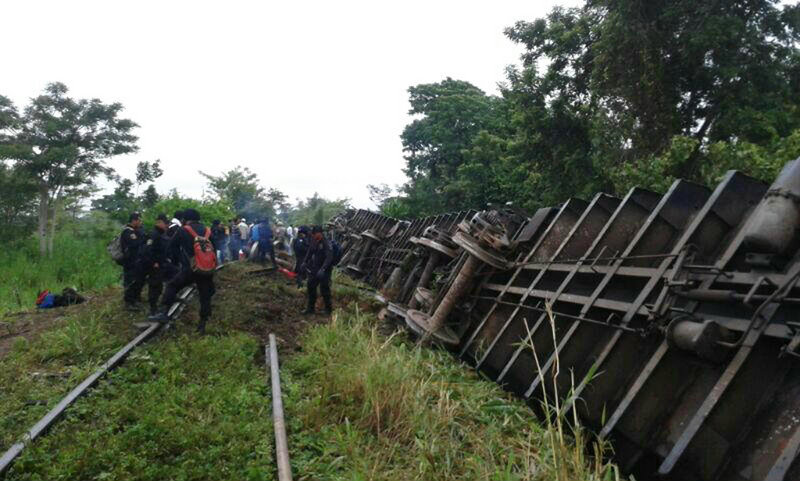 In this photo released by the Civil Protection agency in the State of Tabasco, police agents work at the site where eight of a freight train’s 12 cars derailed Sunday in Mexico.