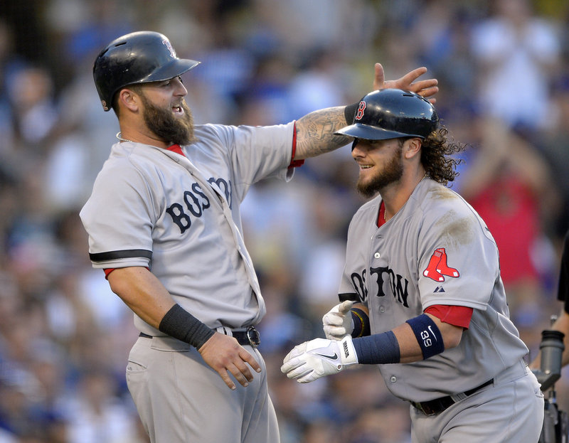 Mike Napoli, left, congratulates Jarrod Saltalamacchia after scoring on Saltalamacchia’s home run in the sixth inning Sunday against the Los Angeles Dodgers. Napoli also homered and drove in three runs in an 8-1 victory.