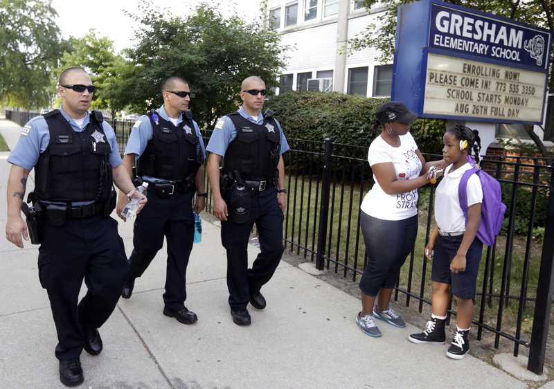 Chicago police patrol as Crystal Stovall delivers her niece Kayla Porter from their south side home to Gresham Elementary School on the first day of classes Monday.