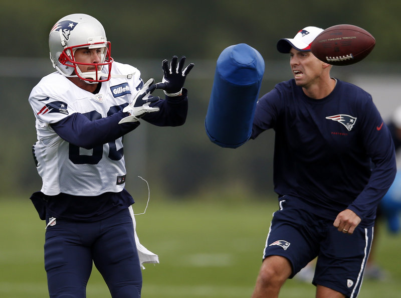 New England’s Danny Amendola catches a pass as receivers coach Chad O’Shea defends during the Patriots’ practice at Foxborough, Mass., on Monday. Amendola has returned to practice after sitting out last week, including the 40-9 preseason loss at Detroit on Thursday.