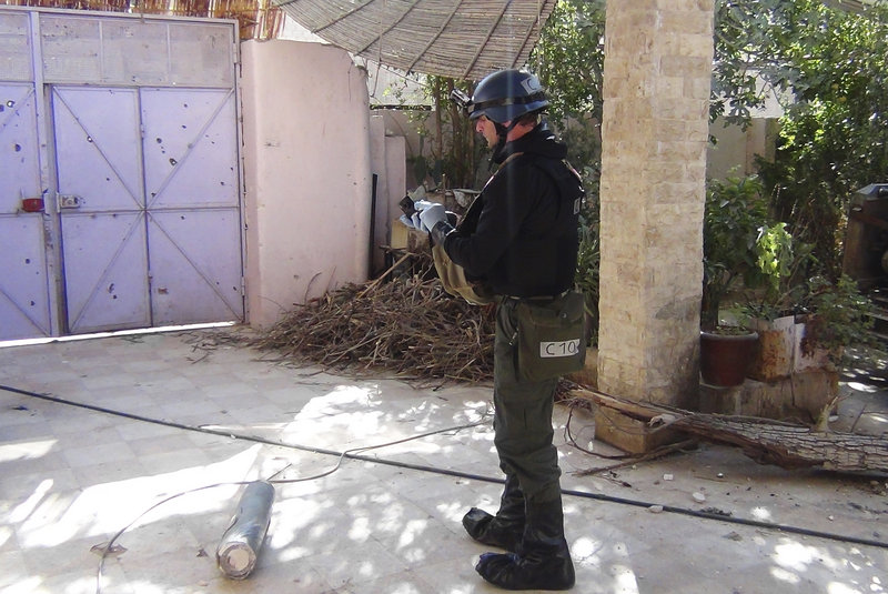 A U.N. inspector gathers evidence at one of the sites of an alleged poison gas attack in the southwestern Damascus suburb of Mouadamiya on Monday.