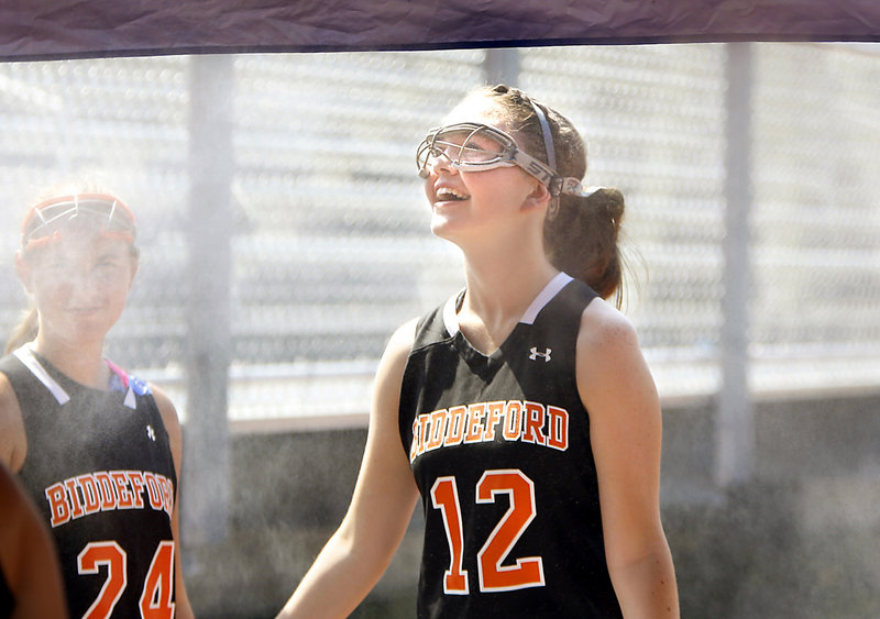 Biddeford’s Charlotte White cools off at a misting tent after the Tigers’ scrimmage against South Portland on Tuesday.