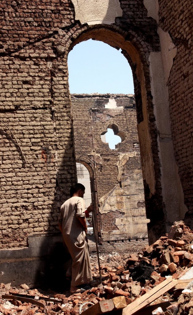 A man walks in the ruins of the Evangelical Church of Malawi, in Malawi, Egypt, on Aug. 17 after it was looted and burned by a mob.