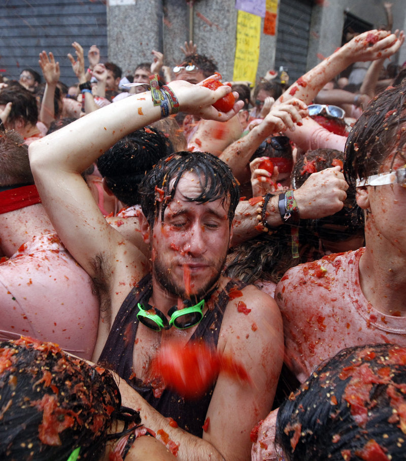 People throw tomatoes at each other during the annual “Tomatina” food fight fiesta in the village of Bunol, Spain.
