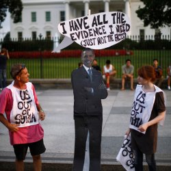 Protesters against U.S. military intervention in Syria are pictured as they set up a cardboard cutout of U.S. President Obama, during a rally outside the White House in Washington