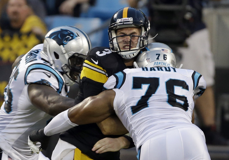 Pittsburgh quarterback Landry Jones gets sandwiched by Carolina’s Charles Johnson, left, and Greg Hardy during the Panthers’ 25-10 exhibition win at Charlotte, N.C., on Thursday.