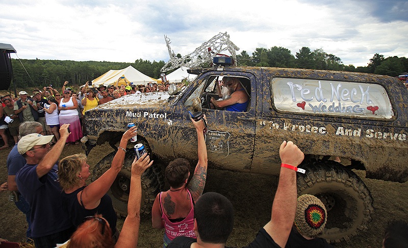 Fans of the Redneck (Blank) Games, formerly the Redneck Olympic Games, in Hebron cheer as a monster truck carrying Lucretia Blais to her wedding with Jeff Gould arrives at the main stage Saturday. A production team from the History Channel chronicled the festivities.