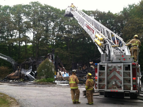 Firefighters continue to work at what is left of Wescustogo Hall in North Yarmouth on Friday morning.