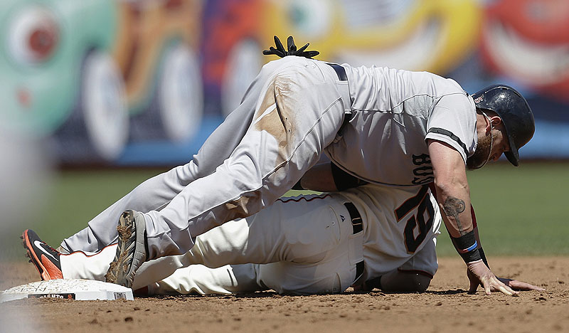 Boston’s Jonny Gomes lies on top of Giants second baseman Marco Scutaro after being tagged out during third-inning action of Wednesday afternoon’s game in San Francisco, won convincingly by the Red Sox. AT&T Park
