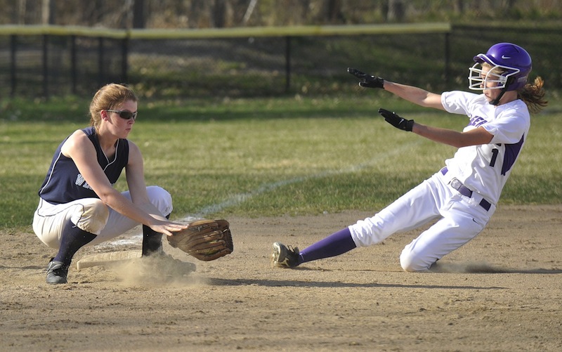 In this April 2012 file photo, Deering High's Nicole Mason slides safely into third base as Westbrook third baseman Mikaela Carey takes the throw. The U.S. Department of Education said Thursday, Sept. 27, 2013 it has reached an agreement with Portland's public schools to ensure that female students in the district will have athletic opportunities that are equal to those of boys.