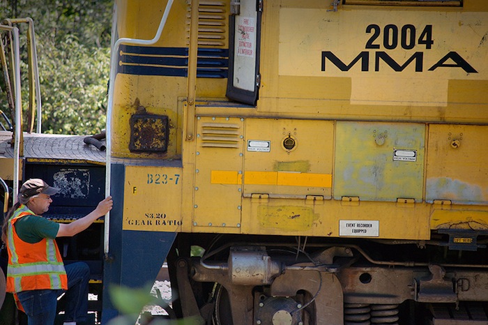 In this July 2013 file photo, a crew from Montreal, Maine & Atlantic Railway works to put a derailed locomotive back on the tracks in Brownville. The Maine railway is seeking a loan that would allow it to operate through bankruptcy.