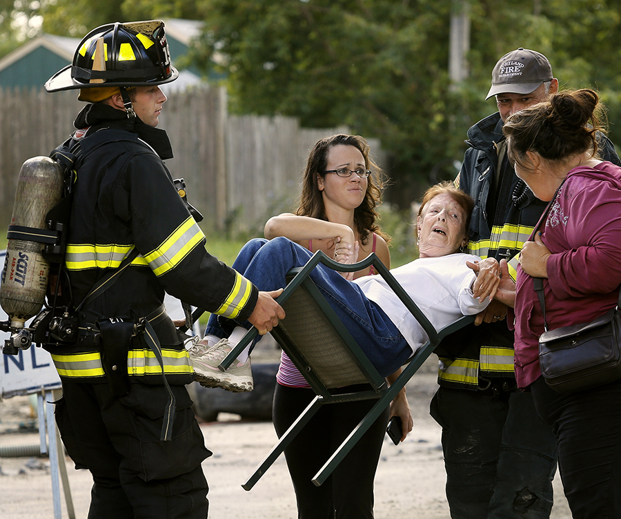 Catherine Lock of 120 Front Street is carried along Johansen Street by Josh Tripp, left, and Sean Meehan after a gas line break caused Portland firefighters to evacuate residents from the area. Also pictured are Lock's neighbors Becca Randall and Patty Fitsimmons, right. Photographed on September 5, 2013.