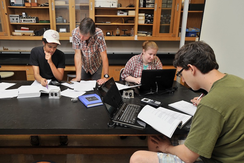 University of Southern Maine physics students work on physics problems Thursday, Sept. 13, 2013 as physics professor Paul Nakroshis, second from left, helps Ramses Damayo, left, a junior at USM. The university is eliminating the physics major because of under-utilization. Other physics majors are junior Deb Hilton, second from right, and senior Trevor Hamer, right.