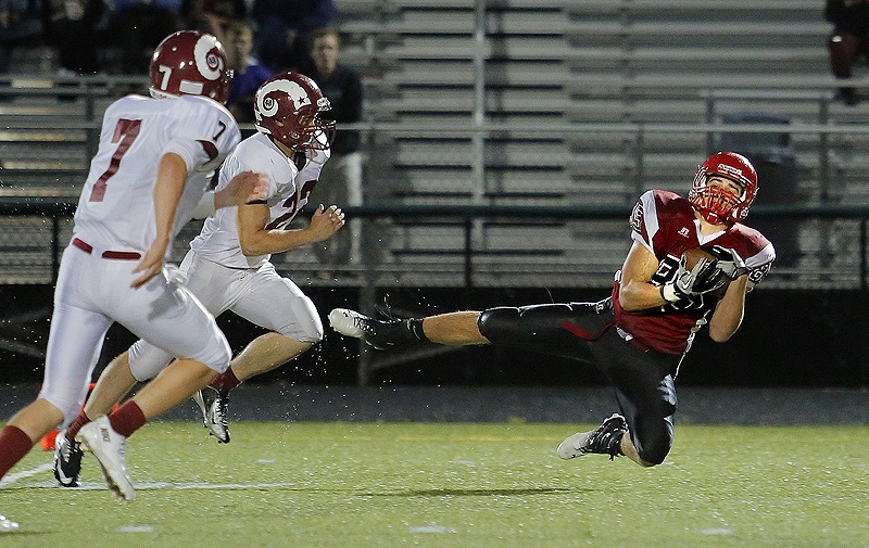 Scarborough High School’s Chris Cyr (85) hauls in a long pass from quarterback Ben Greenberg, not pictured, in front of Bangor defenders James Deane (7) and Alex Weich (22) just before the first half ended Friday. Scarborough went on to defeat Bangor 34-7.