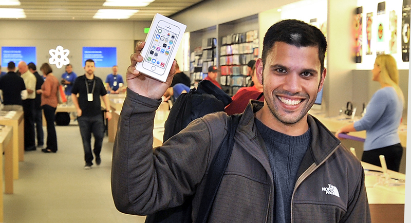 Matthew Baker of Portland is the first to leave the Apple Store at the Maine Mall on Friday with a gold iPhone 5s.