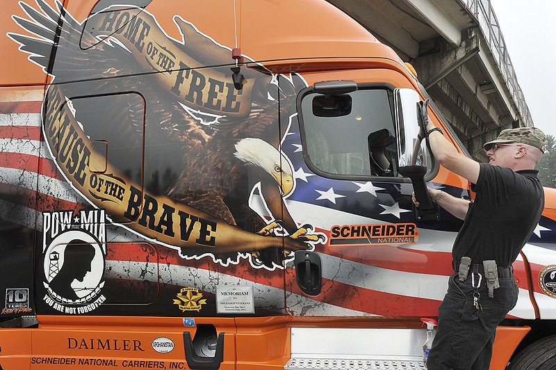 Richard Barczewski, a truck driver for Schneider National trucking, polishes his specially painted truck before the ceremonies at The Ballpark to honor prisoners of war and servicemen missing in action. Schneider National has six similarly painted trucks in its fleet that are driven by veterans only.