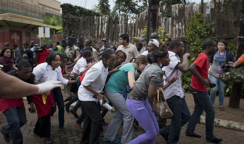 Civilians who had been hiding inside during the gun battle manage to flee from the Westgate Mall in Nairobi, Kenya Saturday, Sept. 21, 2013. Gunmen threw grenades and opened fire Saturday, killing at least 22 people in an attack targeting non-Muslims at an upscale mall in Kenya's capital that was hosting a children's day event, a Red Cross official and witnesses said. (AP Photo/Jonathan Kalan)
