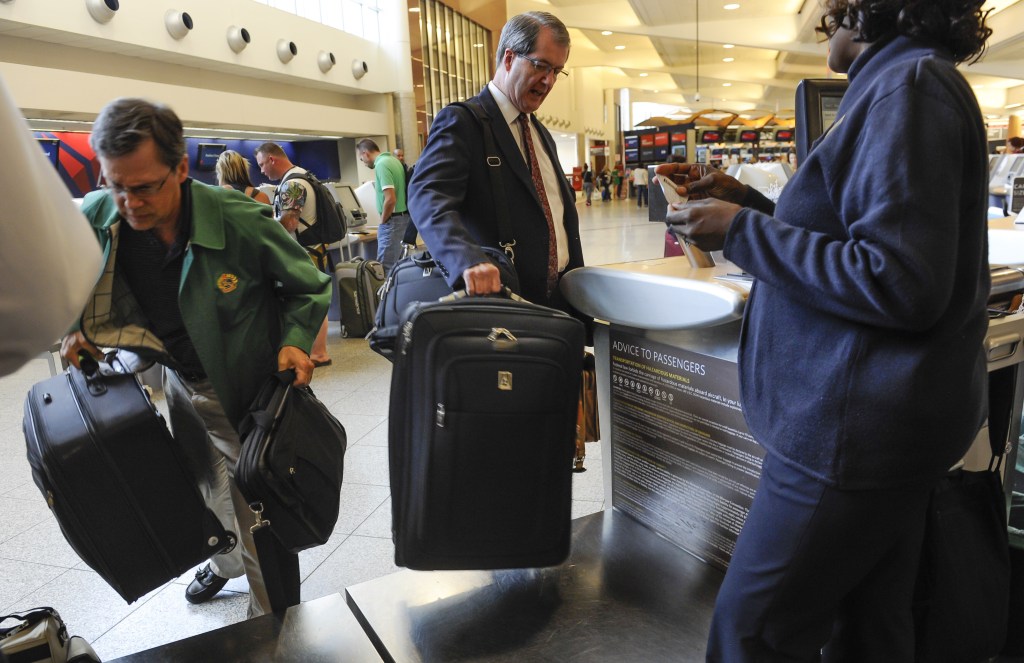 Passengers check their luggage at the Delta counter at Hartsfield-Jackson Atlanta International Airport, in Atlanta last week. Delta customers have the new option to purchase an upgrade that includes a second bag to check, among other perks.
