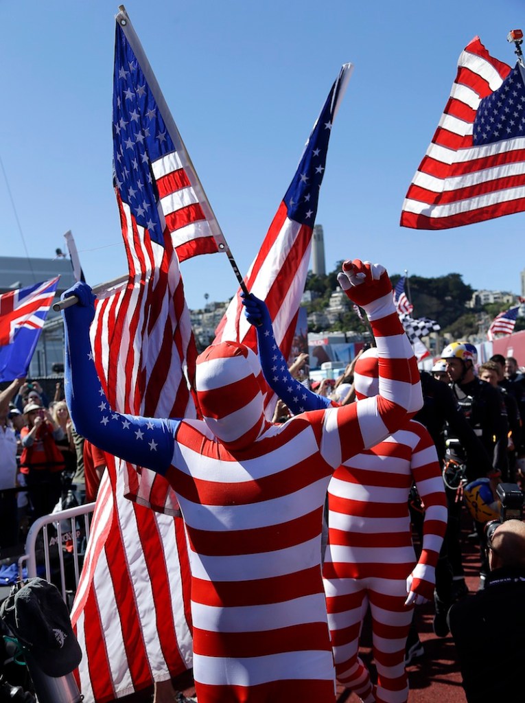 Oracle Team USA fans cheer during a dockout show prior to the 19th race of the America's Cup sailing event against Emirates Team New Zealand Wednesday, Sept. 25, 2013, in San Francisco.