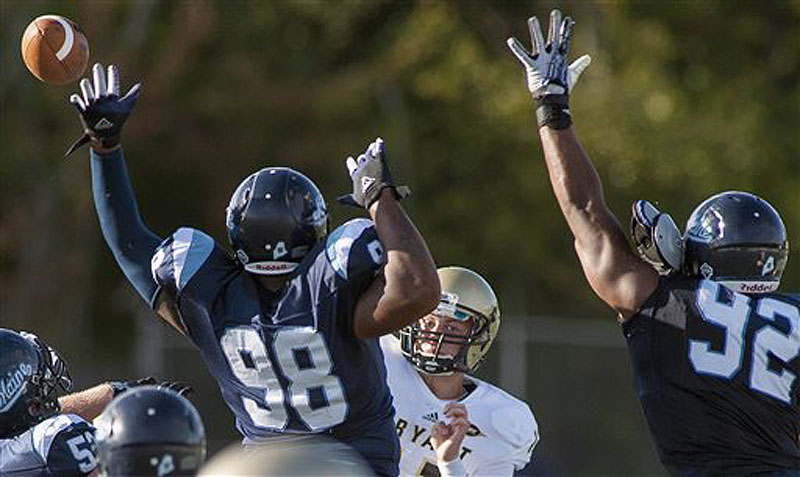 Maine football players Darius Greene (98) and Trevor Bates (92) try to block a pass from Bryant quarterback Mike Westerhaus in the first half Saturday.