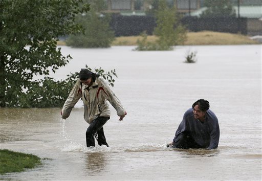 A couple plays in flood water at Utah Park in Aurora, Colo., on Thursday.