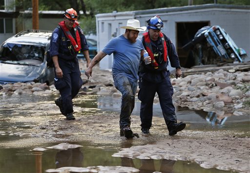 Suffering from dehydration, Lyons, Colo., resident Fred Rob gets help from emergency responders as he leaves his neighborhood after floods left homes and infrastructure in a shambles.