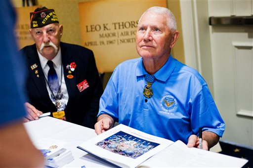Major Leo K. Thorsness gets ready to sign a book for a fan on Thursday at the Gettysburg, Pa., conference. Thorsness, a Medal of Honor recipient, served in the Air Force in Vietnam. At left is State Sr. Vice Commander Gary R. Smith of Pennsylvania Veterans of Foreign Wars.