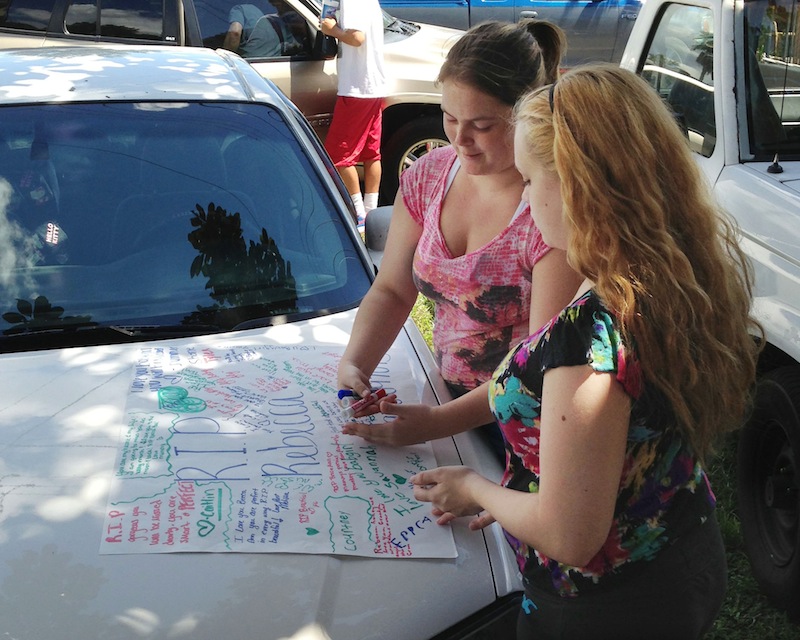 Summer Howard, 19, and Alecia Wilkins, 18, make a poster for Summer's sister, Rebecca Sedwick. Polk County Sheriff Grady Judd said that Sedwick jumped to her death Monday at an old cement business in Lakeland, Fla. Officials are looking into whether they can file charges under a new Florida state law that covers cyber-bullying.