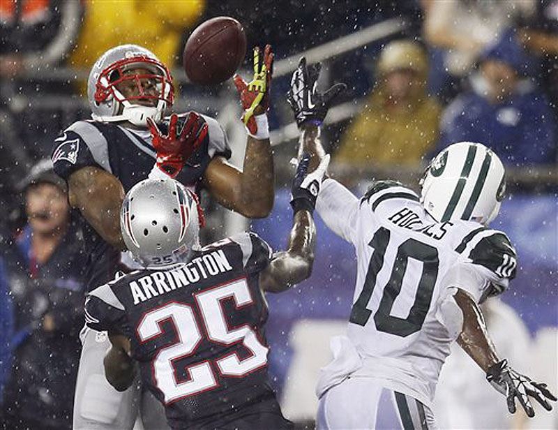 Patriots cornerback Aqib Talib, left, intercepts a pass intended for Jets wide receiver Santonio Holmes (10) in front of Patriots cornerback Kyle Arrington (25) in the fourth quarter Thursday in Foxborough, Mass. NFLACTION13;