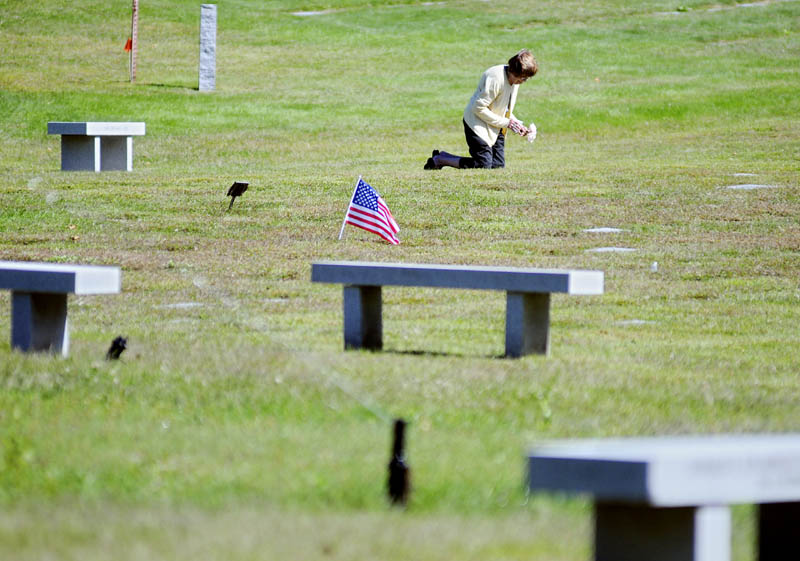 Betty Marchant places flowers Monday September 9, 2013 on the plots of her brother and sister-in-law at the Maine Veterans Memorial Cemetery in Augusta.